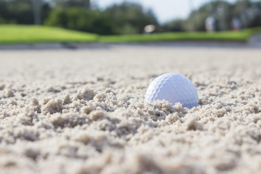 Golfball im Sandbunker.